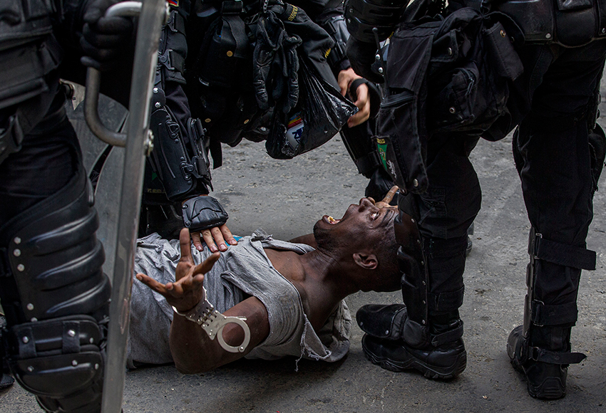 На снимке колумбийца Сантьяго Меса показан арест одного из протестующих во время демонстрации в городе Медельин.
